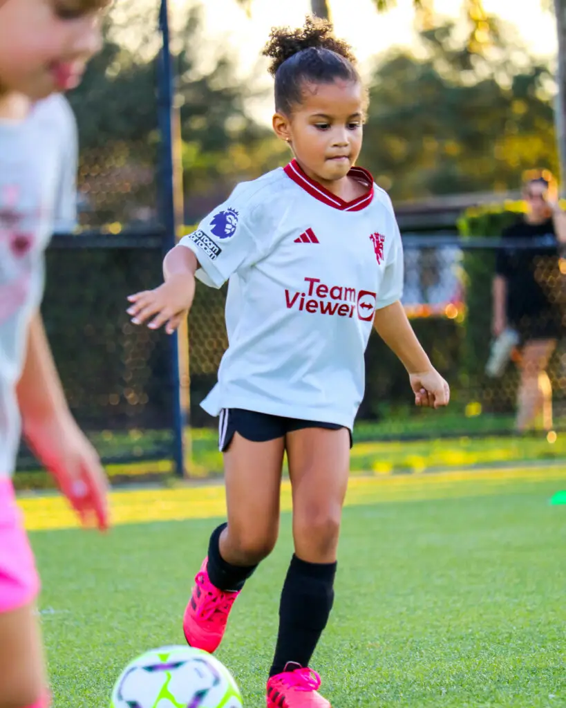 Young ACF Sunrise academy player dribbling a soccer ball during evening training at Nob Hill Soccer Park