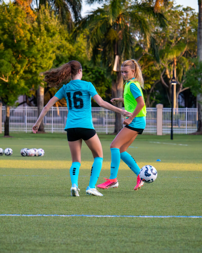 Two teen acf youth soccer players competing on the field during an acf training session in broward county florida.